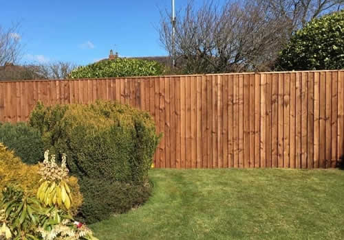 vertical board wooden fence installed on sunny day in westhoughton
